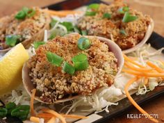 some food is sitting on a plate with lemon wedges and green onion garnishes