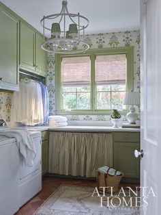 a washer and dryer in a green kitchen with floral wallpaper on the walls