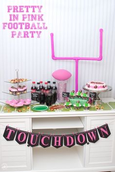 a party table with pink and green decorations on it's side, including cake