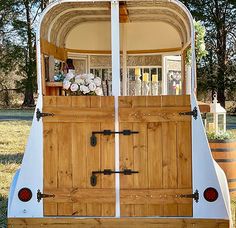 an old fashioned boat with wooden doors is parked in the grass