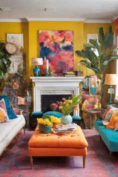 a living room filled with lots of furniture and colorful paintings on the wall above it