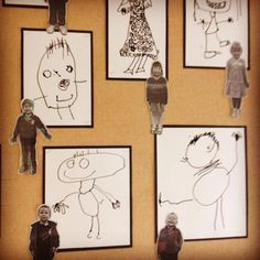 several children's drawings are hanging on the wall