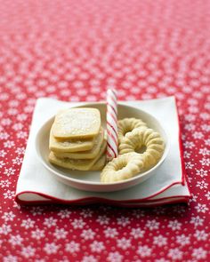 a white plate topped with cookies and pretzels on top of a red table