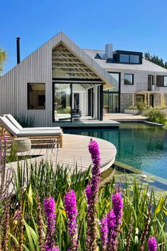 a house with a swimming pool surrounded by purple flowers