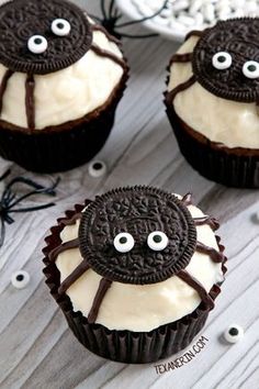 three halloween cupcakes with white frosting and spider web decorations on top, one decorated in chocolate