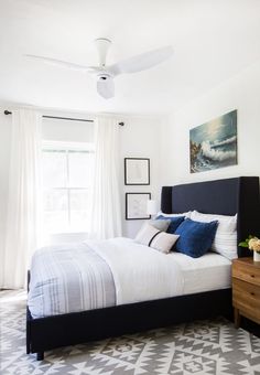 a bedroom with a bed, dresser and ceiling fan