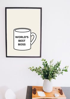 a coffee mug with the words world's best boss on it next to a potted plant