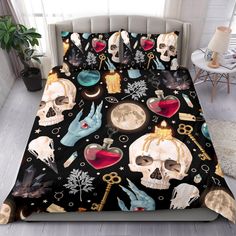 a bed covered in black sheets with skulls and other items on the cover, next to a potted plant