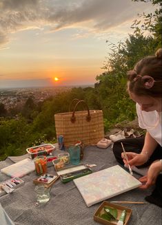 a woman sitting on top of a table holding a paintbrush