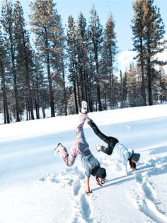 two people are playing in the snow with their feet up and one is upside down