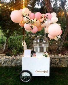 an ice cream cart with balloons in the shape of flowers