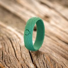 a green ring sitting on top of a wooden table