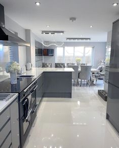 a modern kitchen with stainless steel appliances and white flooring is pictured in this image