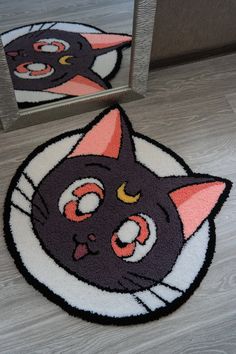 a black cat rug on the floor in front of a mirror