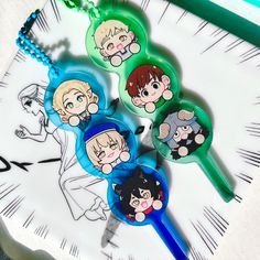 four cartoon keychains sitting on top of a clock