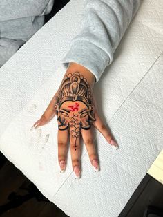 a woman's hand with a tattoo on it and red cross in the middle