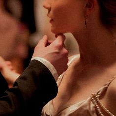 a man and woman in formal wear standing next to each other with their hands on their chins