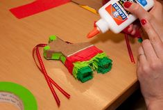 a person is decorating a gingerbread house with crepe paper and glue