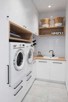 a washer and dryer in a small room with white walls, cabinets and drawers