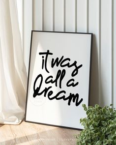 a black and white poster that says it's all a dream next to a potted plant