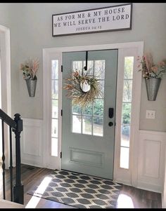 the front door is decorated with flowers and wreaths on it's post, along with an entryway sign that says as for me & my house why will serve the look