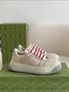 Embrace vintage-inspired style with a modern twist in these Gucci Screener-inspired sneakers. The beige upper, accented with subtle monogram detailing and pops of mint green and red, creates a fresh and playful look. The chunky sole and mixed material construction add retro athleticism, while the overall design exudes a sense of understated luxury. Perfect for those seeking a statement sneaker with a vintage vibe. Luxury Custom Beige Sneakers With Gum Sole, Luxury Green Custom Sneakers With Speckled Midsole, Luxury Green Custom Sneakers For Streetwear, Gucci Snake Sneakers, Gucci Screener, Understated Luxury, Buy Gucci, Loafer Sneakers, Bottega Veneta Shoulder Bag