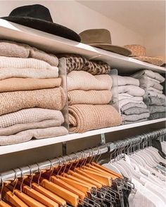 an organized closet with clothes and hats