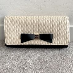 - Handheld Clutch In Natural Straw And Smooth Leather - Front Iconic Bow Detail Engraved With Kate Spade New York Signature - Fold Over Flap With Hidden Magnetic Closure - The Lined Interior Has A Flat Slip Pocket - Color: Black/Natural - Dimensions: 5''H X 9''W X 1''D Elegant Black Summer Clutch, Kate Spade Elegant Formal Clutch, Elegant Kate Spade Clutch For Formal Occasions, Elegant Formal Kate Spade Clutch, Formal Kate Spade Clutch, Chic Rectangular Kate Spade Clutch, Leather Satchel Handbags, Small Tote Bag, Kate Spade Wallet