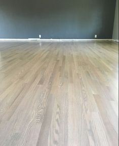 an empty room with hard wood floors and blue walls