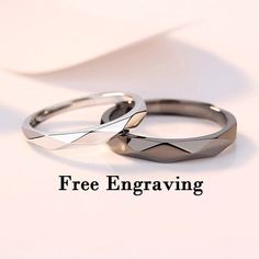 two wedding rings sitting next to each other on top of a white surface with the words free engraving