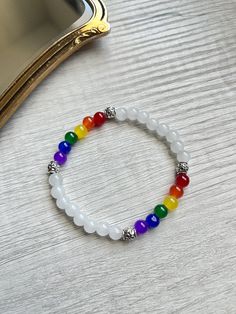 ❤️LGBTQ Bracelet    6mm Glass bead bracelet with silver accents  SIZE: S/M (16cm)  💛JEWELRY CARE: Avoid direct contact with lotions, perfumes and soap or other chemicals that could cause discoloration.  💚TIPS: Remove before showering, swimming, or other water activities. ⚠️ WARNING: Bracelets are made with small beads that could be a choking hazard.  - Do not leave children unattended with jewelry. - Excessive stretching can lead to breaking/ tearing the bracelets Pride Ally Bracelet, White Spiritual Crystal Bracelet With Colorful Beads, Spiritual White Crystal Bracelet With Colorful Beads, White Crystal Bracelet With Silver Beads, Pride Bracelet Diy, Feminist Bracelet, Lgbtq Bracelet, Pride Bracelets, Stretch Beaded Bracelets Diy