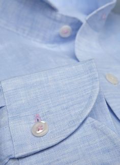 Inspired by the effortless style worn in Portofino, the Alexander in Blue Linen is a must-have of any wardrobe. Crafted of super soft linen fabric, it exudes effortless style when worn untucked. The pink stitching on the top collar button and cuffs adds a polished finishing touch. Worn under a suit and with a tie, the shirt exudes casual ease. The Alexander is the trimmest of all our fits, calibrated to accentuate a lean, athletic body type. • Trimmest Fit • 100% Linen • Spread Collar • Barrel C Light Blue Dress Shirt With Buttons For Spring, Business Linen Tops With Spread Collar, Fitted Linen Dress Shirt For Spring, Fitted Linen Dress Shirt With Spread Collar, Blue Dress Shirt For Summer Daywear, Fitted Blue Linen Shirt, Fitted Linen Business Shirt, Fitted Linen Shirt With Placket, Classic Blue Linen Shirt