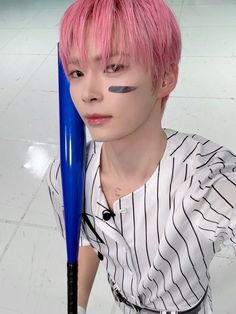 a person with pink hair holding a blue baseball bat