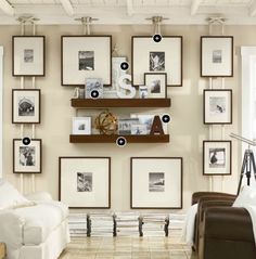 a living room filled with furniture and framed pictures on the wall above it's shelves