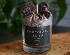 a glass jar filled with chocolate and marshmallows on top of a wooden table