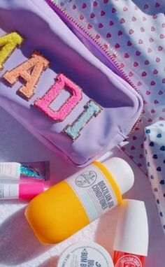 the contents of a personal care bag including lip balm, toothpaste and sunscreen