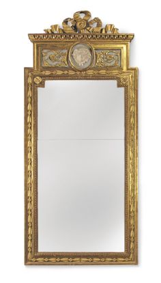 an ornate gold framed mirror against a white wall with a clock on it's face