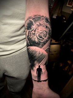 a man's arm with a space themed tattoo on it