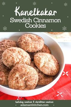 a white bowl filled with cookies on top of a red table cloth and snowflakes