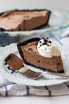 a slice of chocolate pie on a white plate with a fork next to the pie