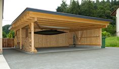 a wooden carport in the middle of a driveway