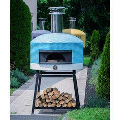 a blue and white outdoor pizza oven sitting on top of a pile of firewood