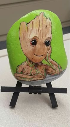 a painted rock with an image of baby groote sitting on top of it