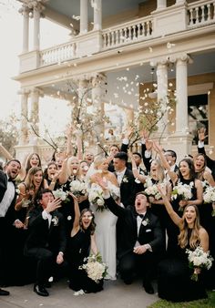 a group of people that are standing in front of a building with confetti