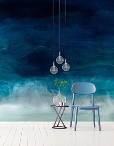 a chair and table in front of a wall with an ocean scene painted on it