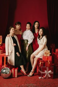 a group of women standing next to each other in front of presents