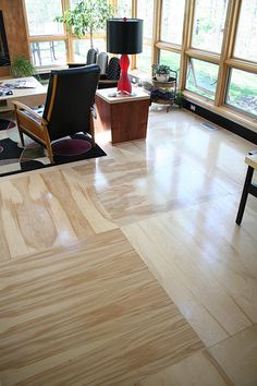 an office with wooden floors and large windows