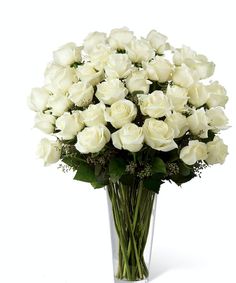 a bouquet of white roses in a clear vase