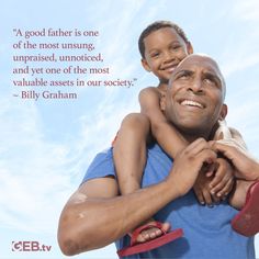 a man holding a young boy in his arms with a quote from billy graham on it