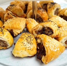 several pastries on a white plate with sesame seeds and black pepper sprinkles